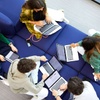 A group of students collaborating on laptops in a casual setting.