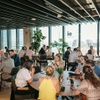 A busy dining area with people conversing and enjoying drinks at tables.