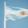 The Argentine flag waving under a clear blue sky.
