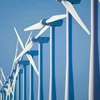 A line of wind turbines against a clear blue sky.