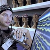 A man wearing an EEG cap observes brainwave readings on a monitor.