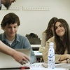A classroom scene where students are engaged in a discussion about technology's impact.