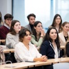 A group of students attentively listening in a classroom setting.