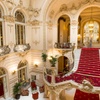 A luxurious grand staircase in an opulent hotel lobby with ornate decor.