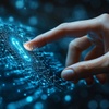 A hand touching a glowing digital interface.