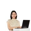 A woman smiling while working on a laptop.