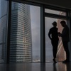 A couple is silhouetted against large urban skyscrapers.