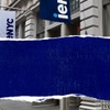 A street view showcasing a building with a blue sign.