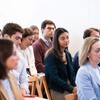 A focused group of people attentively listening to a presentation.