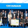 A group of people, including business professionals and students, posing with large checks at an event sponsored by Ryanair and IE University.
