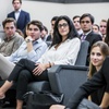 A group of young professionals attentively listening in a seminar setting.