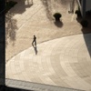A person walking on a circular pathway in a modern urban environment.