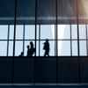 Silhouettes of people walking inside a modern building.
