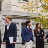 A group of young professionals engaged in a discussion outside a building.