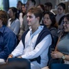 A diverse group of people attending an event, sitting in an auditorium setting.