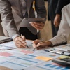 Two people collaborating on business charts and graphs at a table.