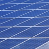 A vast array of blue solar panels under a clear sky.