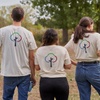 Three IE students giving their bags in the forest