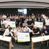 A group of people posing in a classroom environment, holding certificates and smiling at the camera.