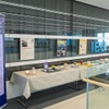 A display of various items and informational posters at an event focused on women and leadership in the arts.