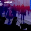 Silhouettes of military personnel in the foreground with a blurred crowd in the background, highlighted by blue and purple tones.