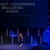 A speaker presenting on governance and ethics at an event.