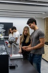 A group of young people are engaged in an interactive science experiment in a modern classroom.
