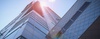 Low angle view of a modern skyscraper with sun flare.