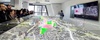 Group of people observing a colorful 3D city model display in a modern office setting.