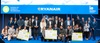 A group of people, including business professionals and students, posing with large checks at an event sponsored by Ryanair and IE University.