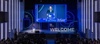A speaker addressing an audience at a welcome event in a university auditorium.