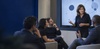 A woman is presenting ideas to a group in a modern meeting room.