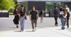 A group of diverse young adults walking together in a bright outdoor setting.