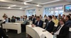 A group of professionals attending a presentation in a modern conference room.