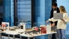 Two individuals are discussing architectural models on a table in a modern office space.