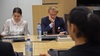 A group of individuals engaged in a serious discussion during a meeting.