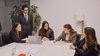 A group of professionals collaborates around a table in a modern office setting.