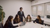 A group of professionals collaborating around a conference table in a modern office.