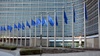 A modern building with numerous blue flags in front of it.
