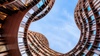 A unique architectural view of curving buildings against a blue sky.