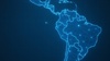 A digital map of Latin America outlined in blue network lines on a dark background.
