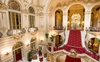 A luxurious grand staircase in an opulent hotel lobby with ornate decor.