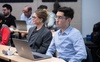 A group of students engaged in a classroom setting with laptops.