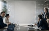 A business meeting in a modern conference room with participants engaged in a presentation.