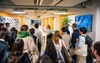 A diverse group of people attending a presentation in a modern workspace.