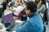 A group of students working on their laptops in a classroom setting.