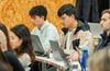 A group of students working on laptops in a classroom setting.