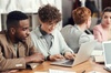 A group of people engaged in a collaborative work environment around a table.