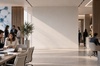 A modern office interior featuring people working collaboratively at tables.