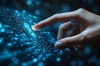 A hand touching a glowing digital interface.
